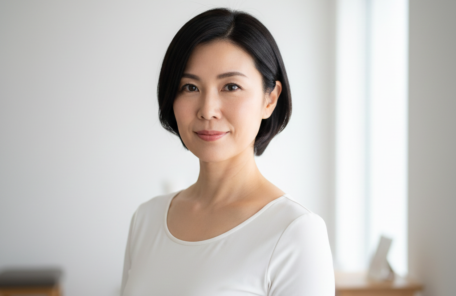 ダイエットに成功し、スッキリとした表情で鏡の前に立つ40代後半の日本人女性。過去の自分を卒業し、自信とやる気を取り戻した晴れやかな様子。