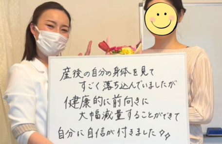 ダイエットに成功したお客様とスタッフの笑顔のツーショット。お客様が「産後の自分の身体を見てすごく落ち込んでいましたが、健康的に前向きに大幅減量することができて自分に自信が付きました✨✨」と書かれたホワイトボードを掲げている様子。