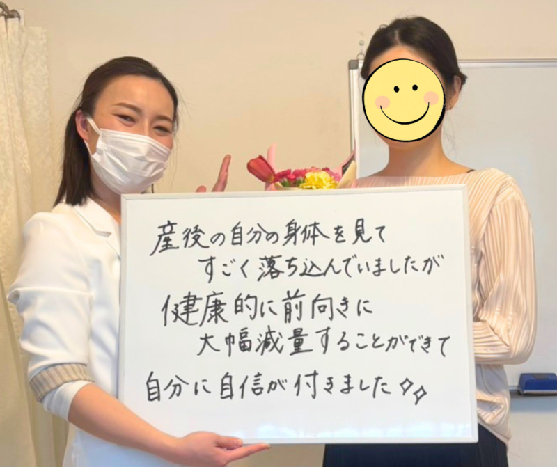 ダイエットに成功したお客様とスタッフの笑顔のツーショット。お客様が「産後の自分の身体を見てすごく落ち込んでいましたが、健康的に前向きに大幅減量することができて自分に自信が付きました✨✨」と書かれたホワイトボードを掲げている様子。